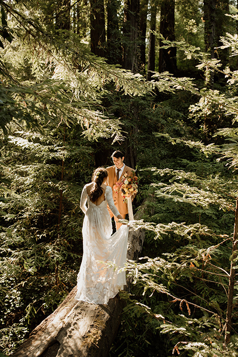  formfitting bridal lace gown with sleeves and the groom in a caramel suit with long tie 