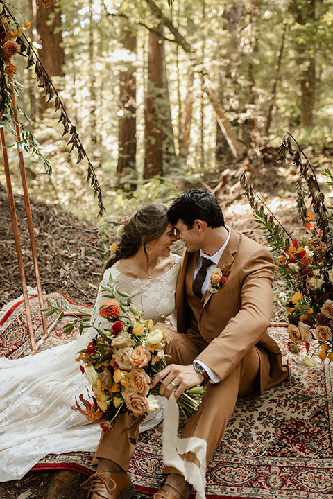  formfitting bridal lace gown with sleeves and the groom in a caramel suit with long tie 