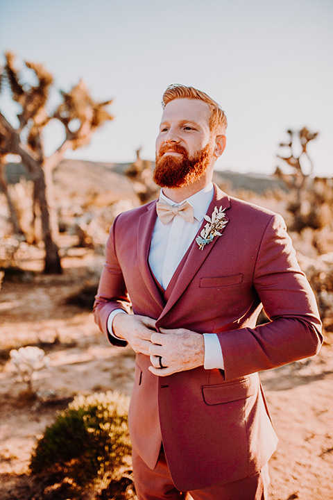  groom in a rose pink suit with a bow tie