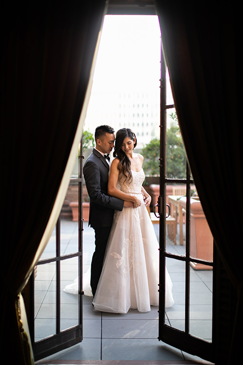  bride in a modern ballgown with a strapless neckline, groom in a charcoal grey suit with a black bow tie 