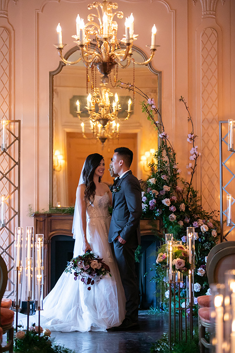  bride in a modern ballgown with a strapless neckline, groom in a charcoal grey suit with a black bow tie 