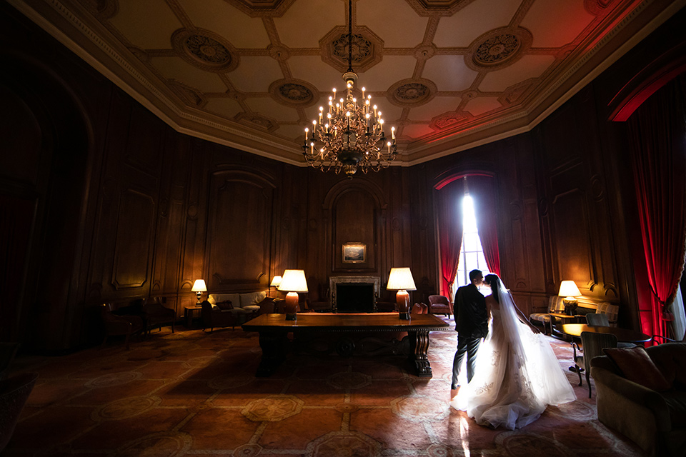  bride in a modern ballgown with a strapless neckline, groom in a charcoal grey suit with a black bow tie 