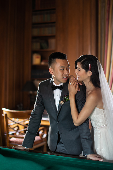  bride in a modern ballgown with a strapless neckline, groom in a charcoal grey suit with a black bow tie 