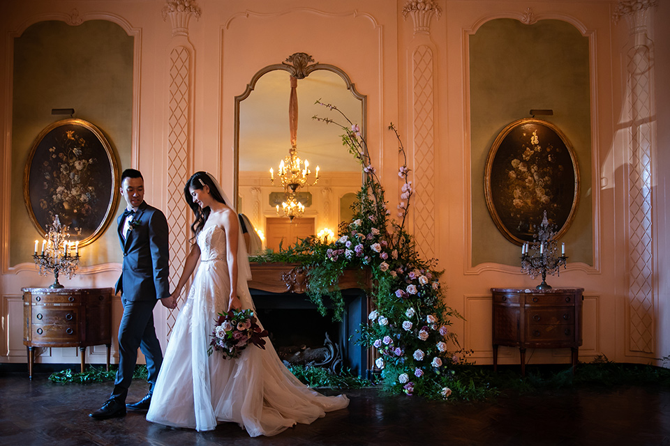  bride in a modern ballgown with a strapless neckline, groom in a charcoal grey suit with a black bow tie 