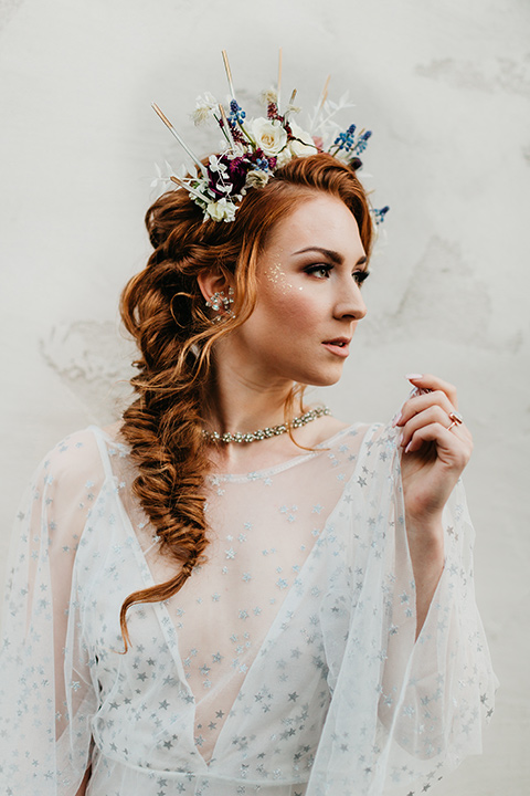  bride in an ivory lace gown with flowing sleeves and a braided hairstyle 