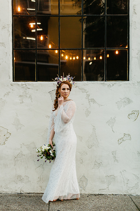  bride in an ivory lace gown with flowing sleeves and a braided hairstyle 