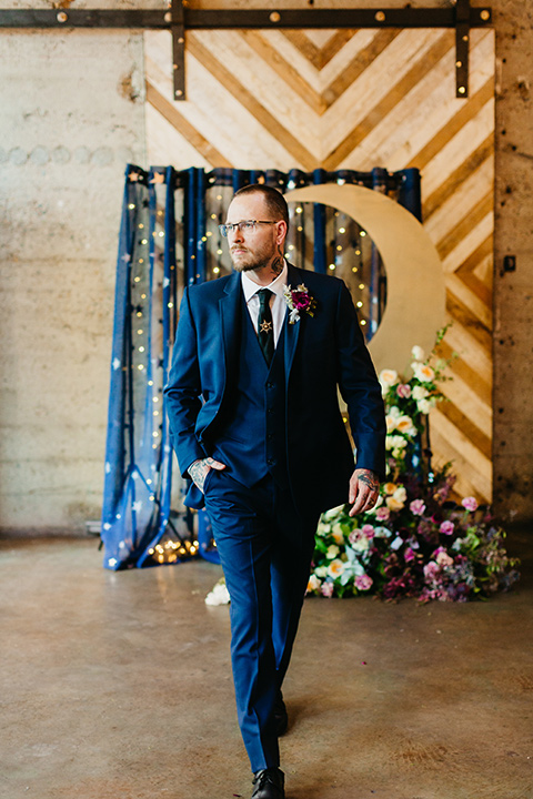  groom in a cobalt blue suit and a black long tie 