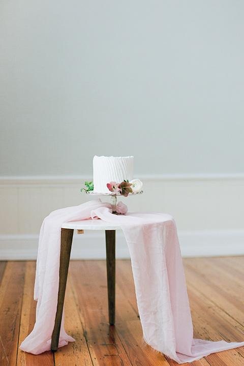  white cake on a table with a blush colored linen covered table