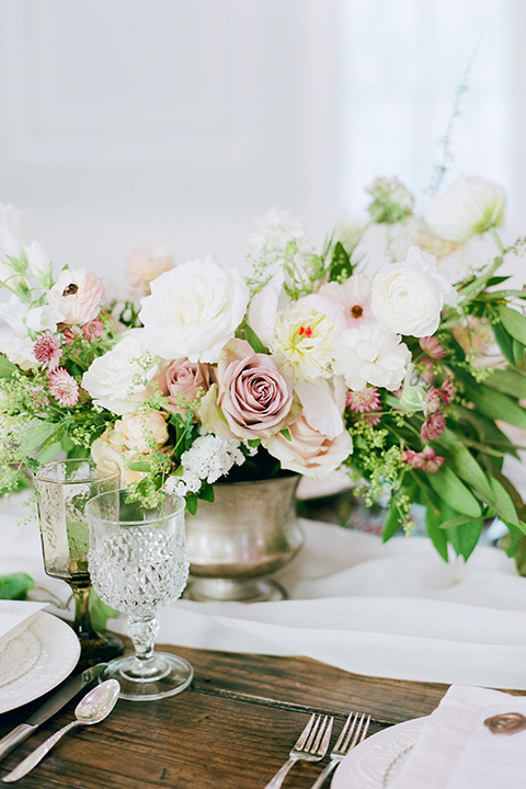  wooden table with white and blush flowers and silver flatware