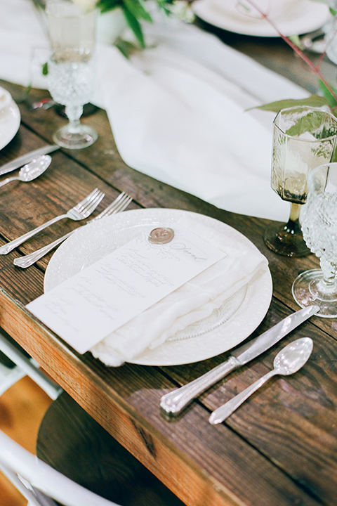  white plates and silver flatware on a wooden table