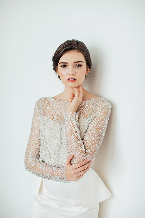  bride in a second gown with an illusion bodice and long sleeves with crystal detailing and a fitted skirt 