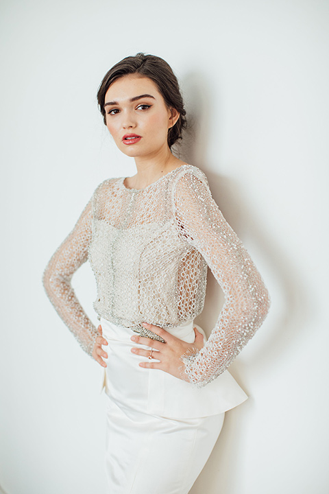  bride in a second gown with an illusion bodice and long sleeves with crystal detailing and a fitted skirt 