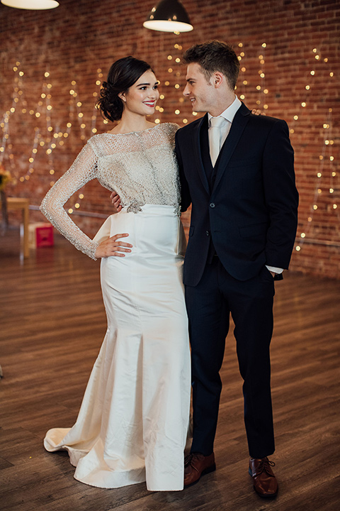  bride in a second gown with an illusion bodice and long sleeves with crystal detailing and a fitted skirt 