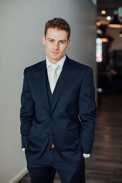  groom in a dark navy suit with a grey tie 