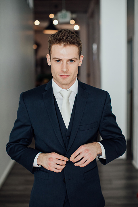  groom in a dark navy suit with a grey tie 