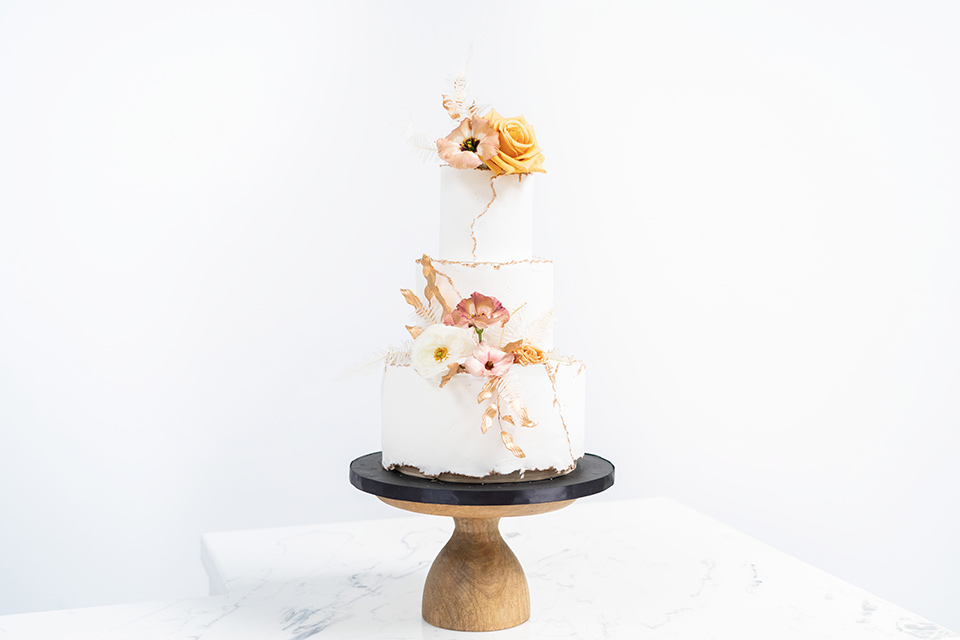  white cake with gold and neutral details 