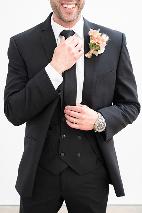  groom in a black suit with a black long tie