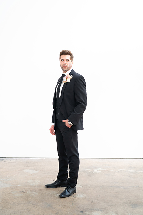  groom in a black suit with a black long tie 