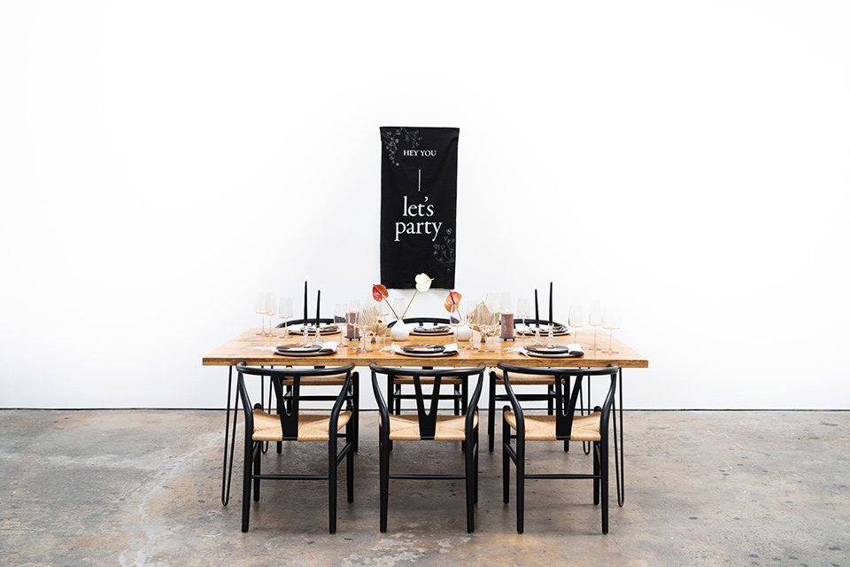  reception table with wood table and black chairs and modern bohemian decor