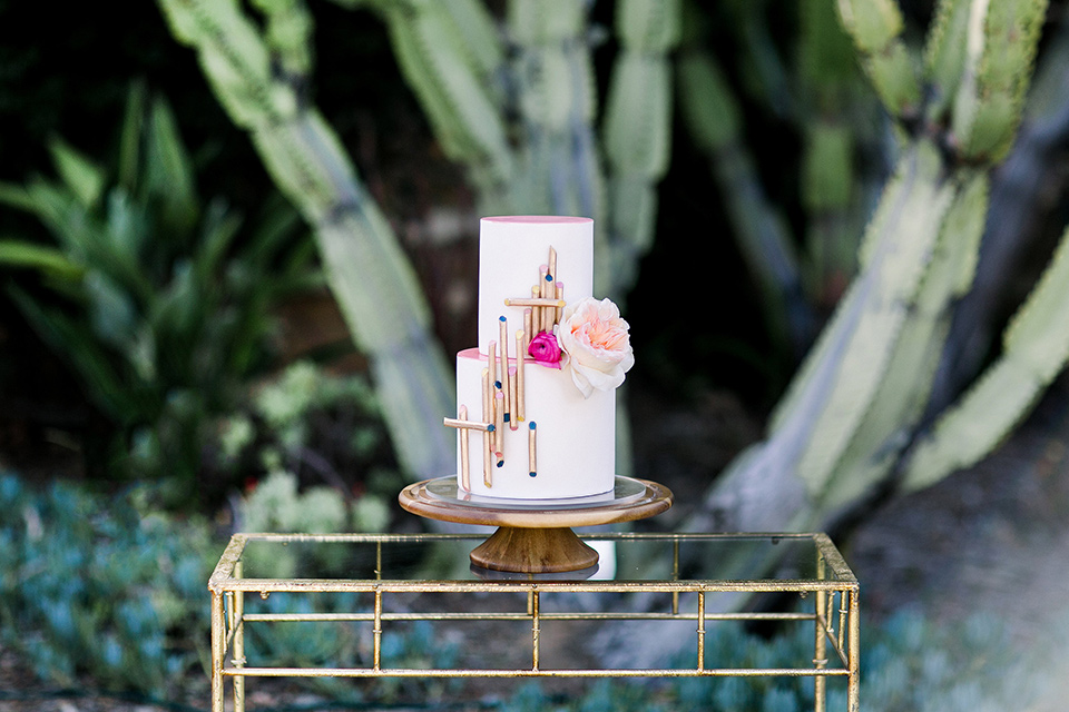  white cake with pink flowers and gold details