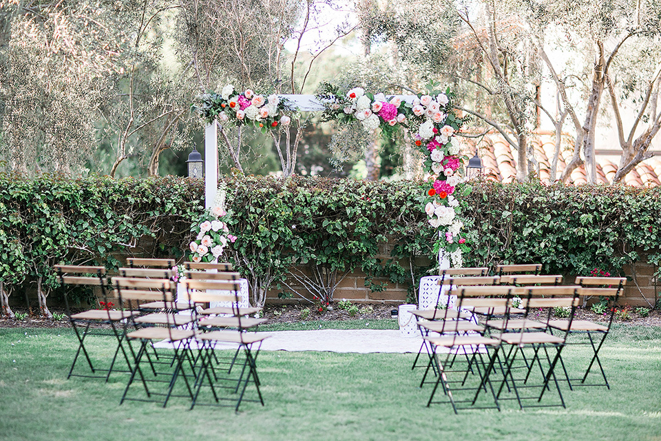  ceremony décor with white flowing linens and wooden chairs and pink flowers