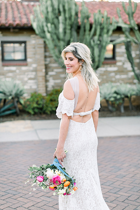  the bride in a white bohemian gown with a high neckline and cold shoulder detail close up