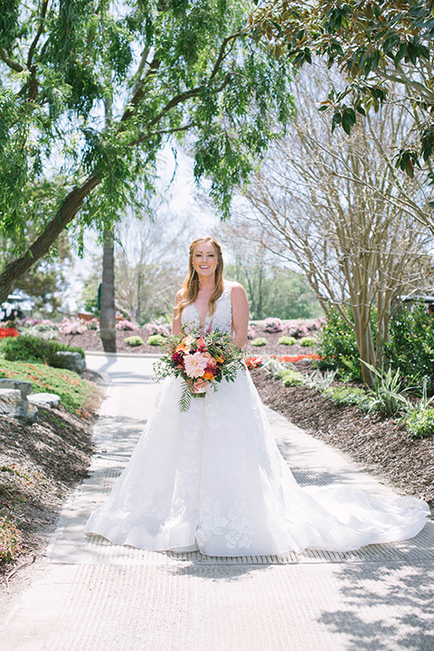  the bride in a flowing a line gown with a lace bodice in a low cut neckline 