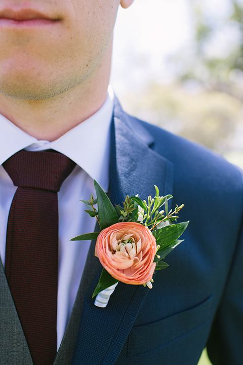  groom in a dark blue suit with a grey vest and burgundy long tie 