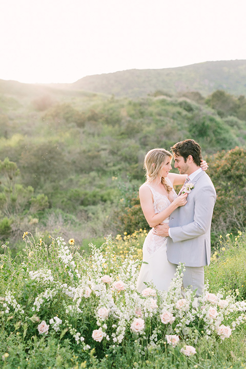  bride in a French inspired casual flowing gown and the groom in a light grey peak lapel suit