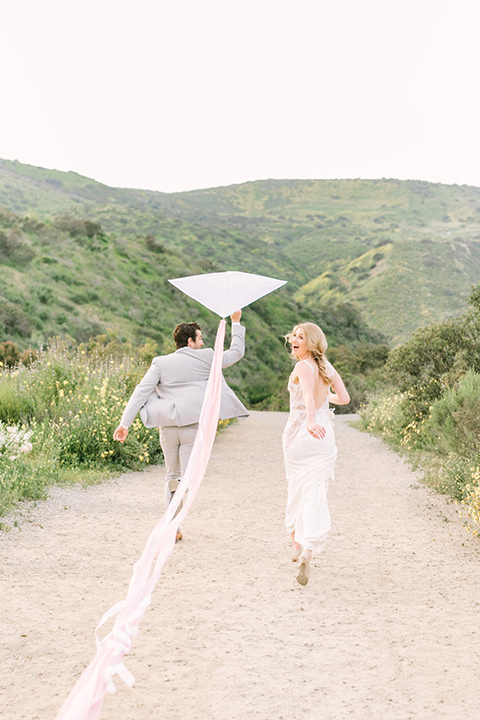  bride in a French inspired casual flowing gown and the groom in a light grey peak lapel suit