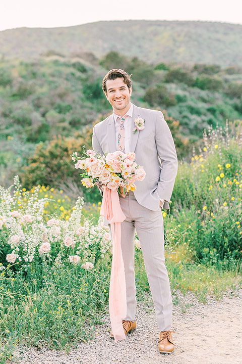  bride in a French inspired casual flowing gown and the groom in a light grey peak lapel suit