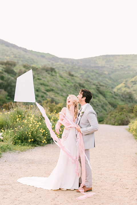  bride in a French inspired casual flowing gown and the groom in a light grey peak lapel suit