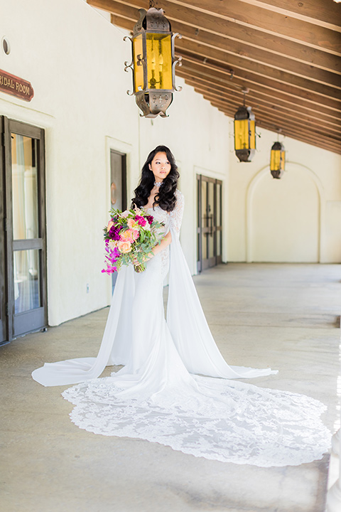  bride in a long gown with a flowing train and cape