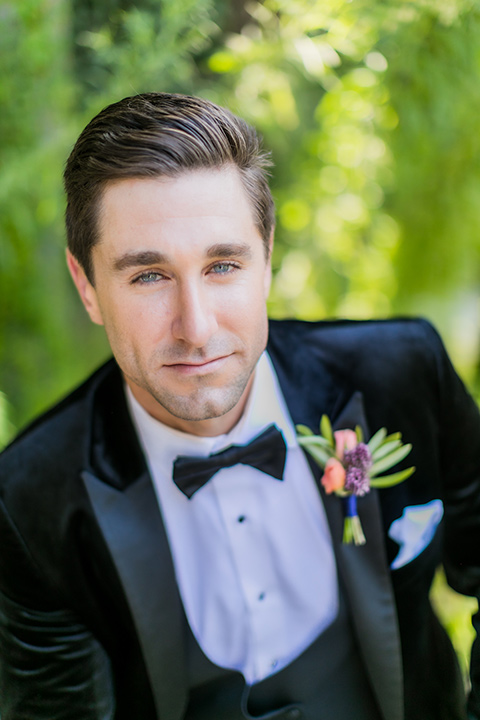  groom in a black velvet tuxedo with a black bow tie 