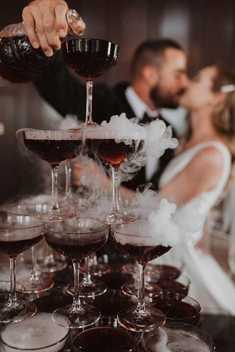  bride in a tulle a line gown with a sweetheart neckline and a crystal bodice and the groom in a black velvet tuxedo and black bow tie by champagne 