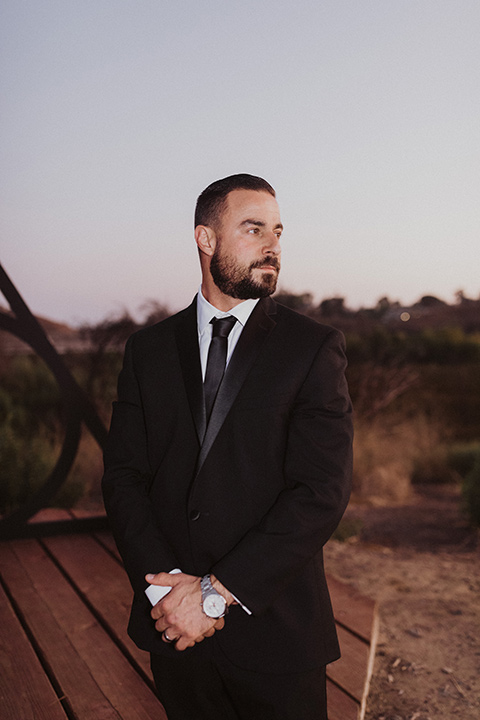  groom in a black velvet tuxedo and black bow tie 