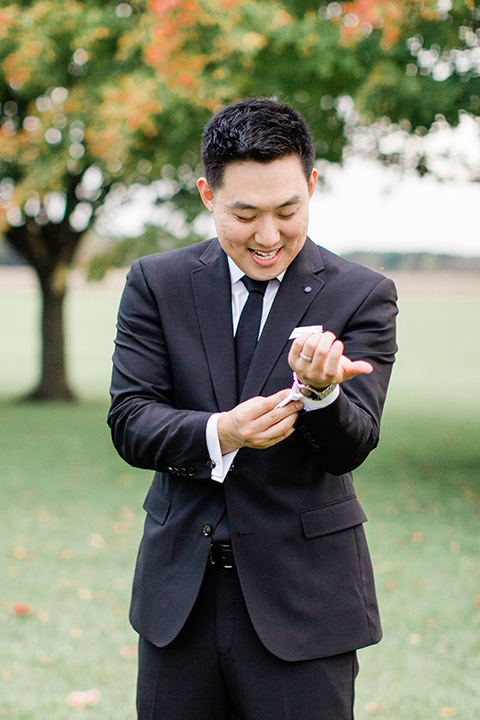  groom in a black suit and long tie