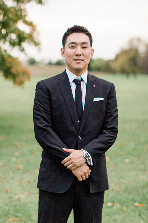  groom in a black suit with a long tie 