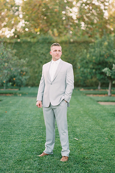 groom in a grey suit with a white long tie