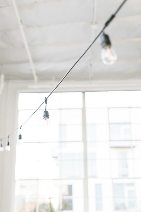  the string lights overhead of the ceremony space 