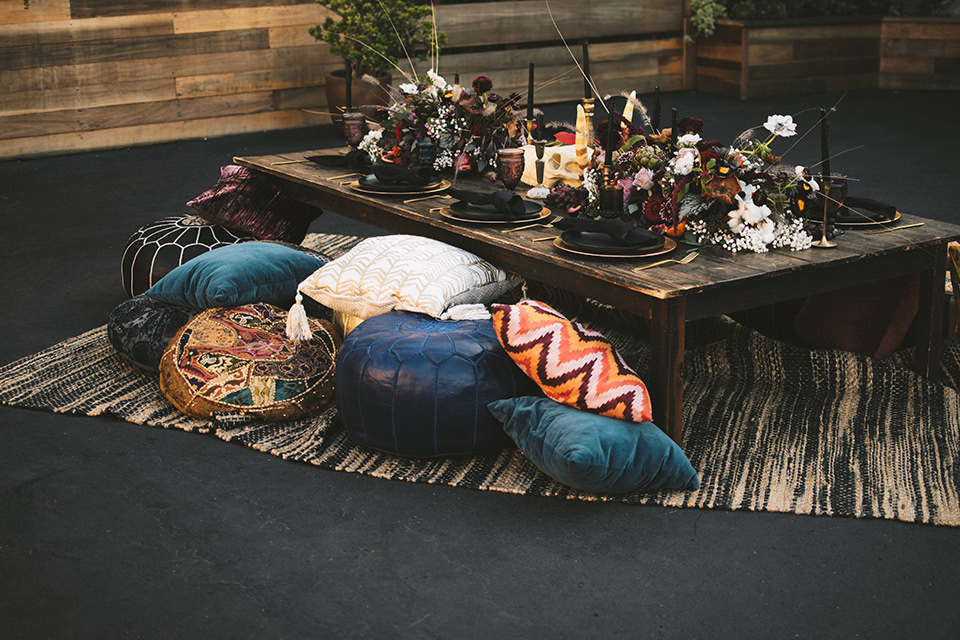  pink and blue floor cushions and pillows with a low wooden table and bohemian rugs 