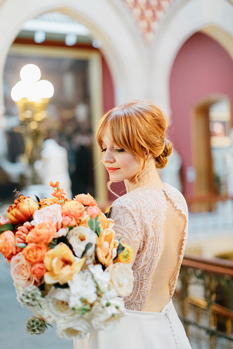  bride in a white ballgown with a crystal bodice and long sleeves with her hair in a low bun