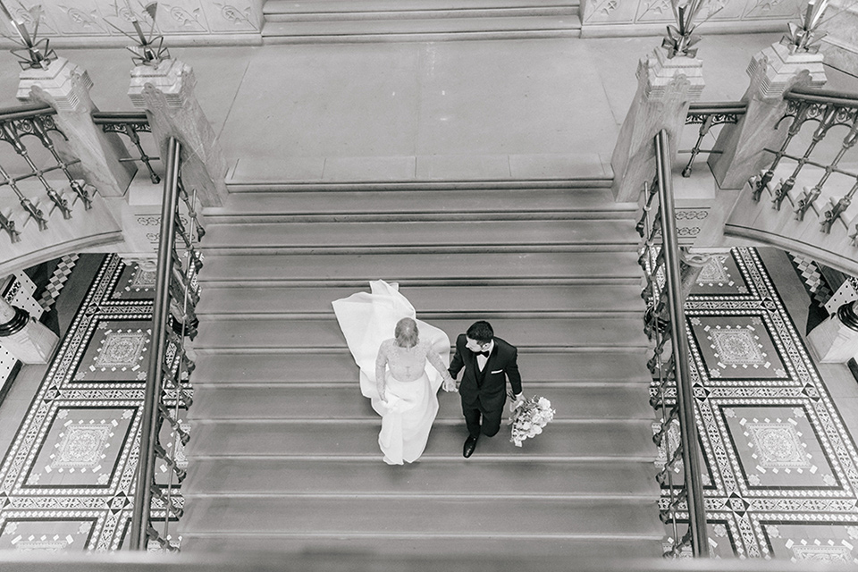  bride and groom walking down the stairs from above