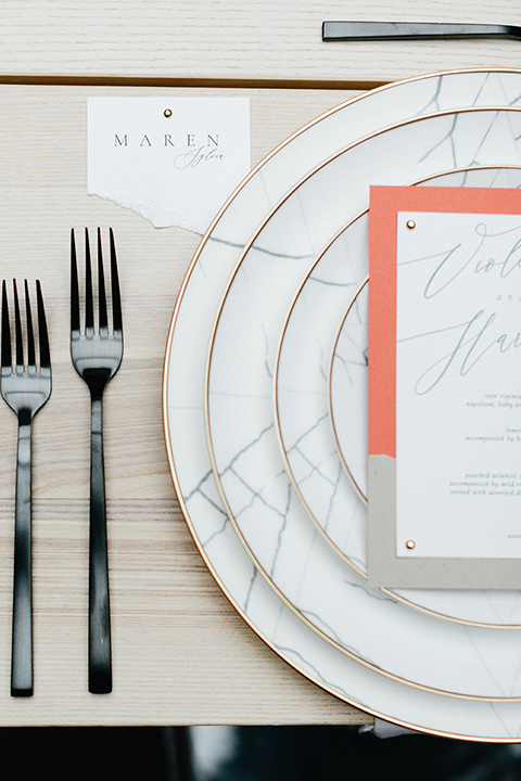  white plates and black flatware on a light wood style table