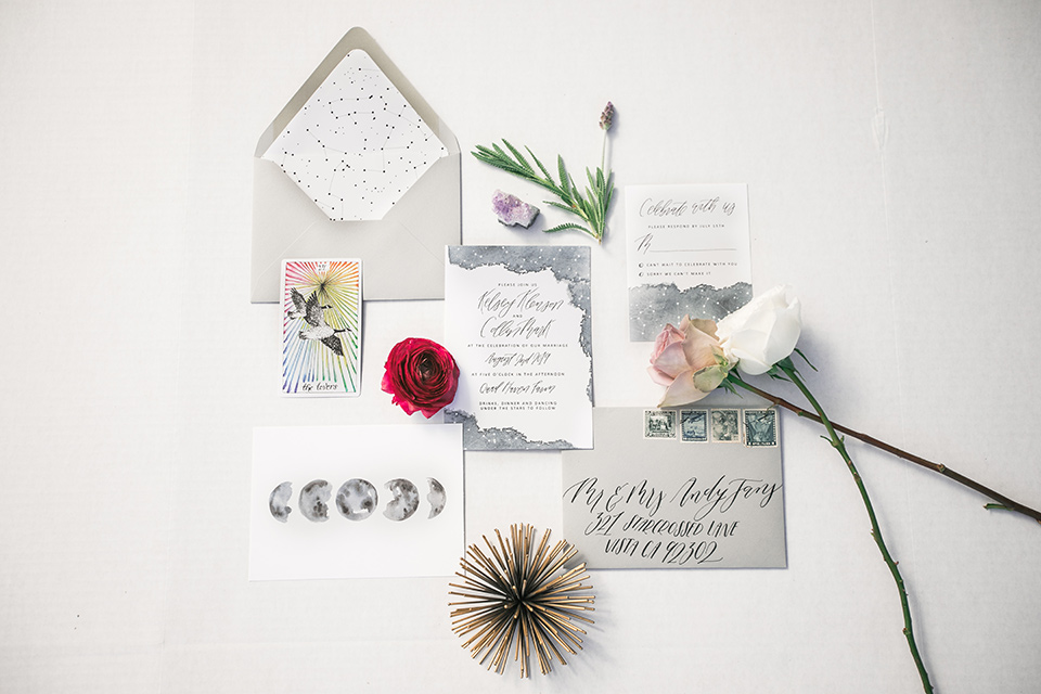  white invitations with calligraphy and a small floral design