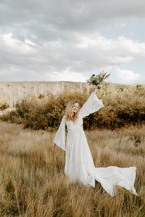  bride in a white lace gown with long flowing sleeves and high neckline 