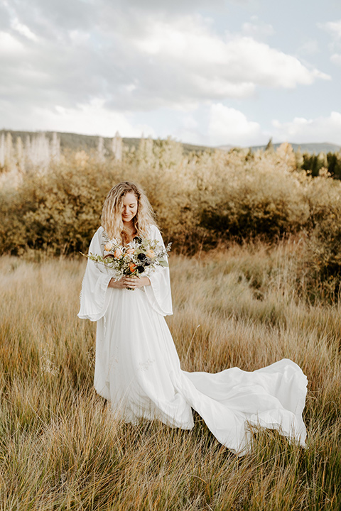  bride in a white lace gown with long flowing sleeves and high neckline