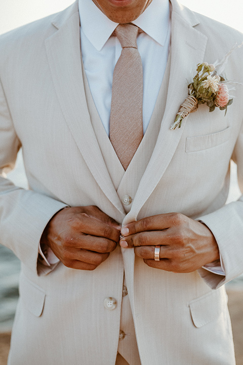  bride in a bohemian white lace gown and the groom in a light tan suit with a caramel long tie 