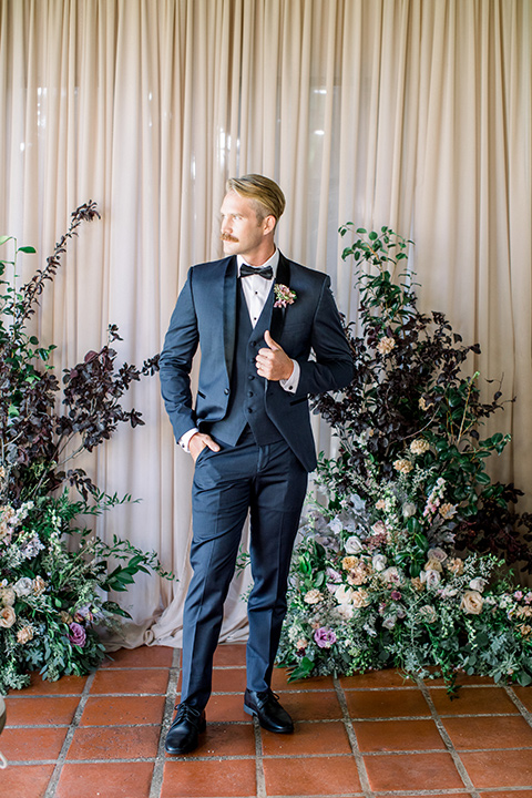  the groom in a navy shawl lapel tuxedo with a black satin lapel 