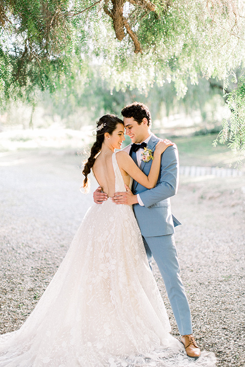  bridal hair with a french braid and crystal and the groom in a light blue suit touching heads